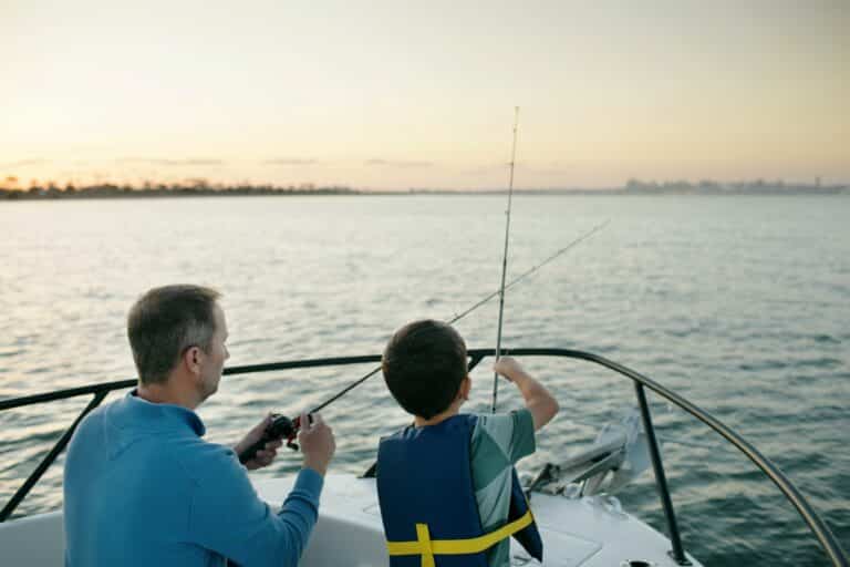 Pai e filho pescando em barco